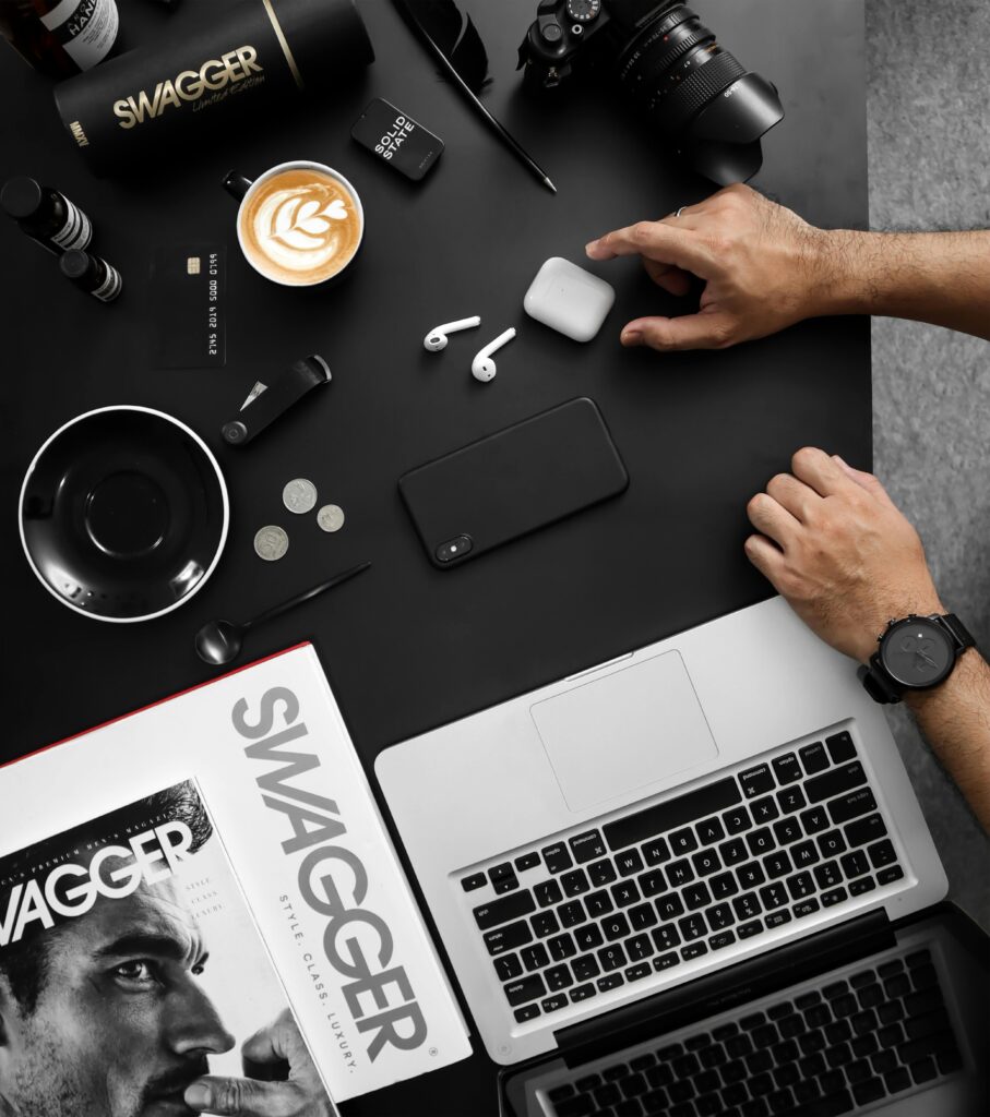 A contemporary workspace featuring tech devices, coffee, and a stylish magazine.